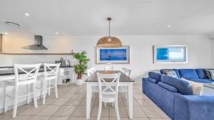 汉密尔顿岛Lagoon Beachfront Lodge 202 on Hamilton Island by HamoRent的客厅配有蓝色的沙发和桌子