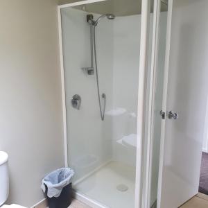 罗托鲁瓦Kuirau Chalet Villa 3-bedroom Twin Lake的浴室里设有玻璃门淋浴
