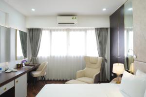 河内宝松国际酒店的酒店客房,配有一张床、一张桌子和椅子