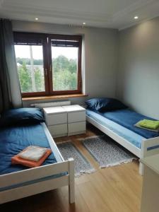 姆拉哥沃Mazury Mrągowo Pokoje Apartament的一间卧室设有两张床和窗户。