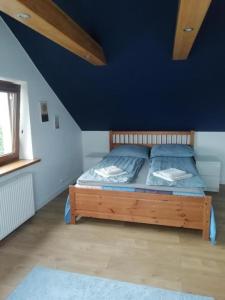 姆拉哥沃Mazury Mrągowo Pokoje Apartament的一间卧室配有一张带蓝色墙壁的木床