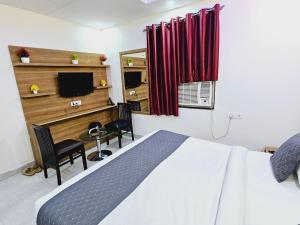 新德里Hotel TU Casa (Stay near International Airport)的一间卧室配有一张床、一张书桌和一台电视