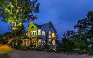 大叻Love Hill Resort的蓝色和黄色的房子