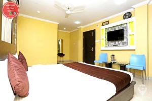 普里Hotel Sai Sandpiper Puri Near Sea Beach的一间带大床和电视的卧室
