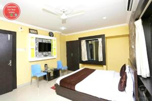 普里Hotel Sai Sandpiper Puri Near Sea Beach的一间卧室配有一张床、一张书桌和一台电视。
