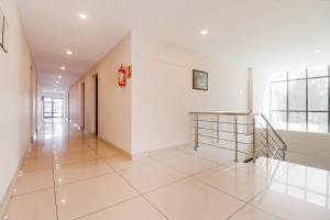KattappanaSuper Capital O Edassery Resort的拥有白色墙壁和楼梯的走廊