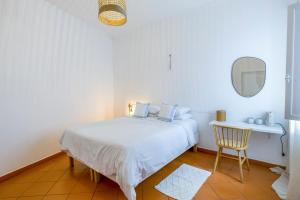 拉戈斯Casa Luma B&B的白色卧室配有床和椅子
