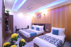 新德里Hotel TU Casa (Stay near International Airport)的酒店客房带两张床和鲜花