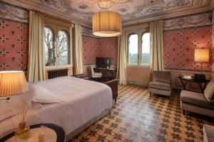 科斯蒂廖莱达斯蒂Villa Pattono Relais的一间卧室配有一张床、一张桌子和一把椅子