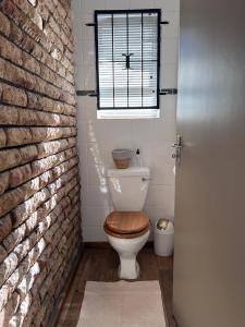 锡特勒斯达尔Aan d'Oewer的浴室设有卫生间、窗户和砖墙