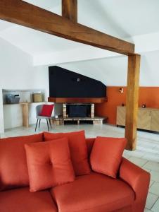 La Chapelle-aux-BoisLa Mansarde的客厅配有红色沙发和平面电视