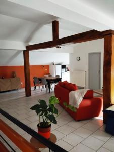 La Chapelle-aux-BoisLa Mansarde的客厅配有红色的沙发和桌子