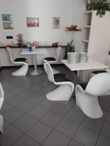 迪马罗B&B Seventy Design的一间设有白色桌椅的用餐室