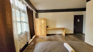 拉冲Wonder Hill Inn的客房设有床、桌子和窗户。