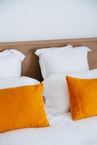 圣马迪拉莫Hôtel Casa Marina的两张带橙色枕头的白色床