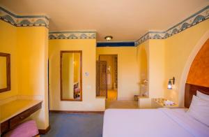 加利布港加利卜港滨海旅舍的卧室设有白色的床和黄色的墙壁