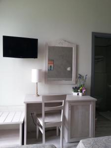 Giannella伊尔丽都酒店的客房设有带椅子和镜子的书桌