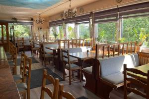 维利希Hotel Restaurant Artemis的餐厅设有木桌、椅子和窗户。