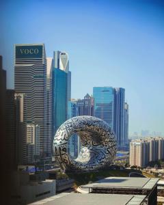 迪拜Ritz Carlton DIFC Downtown Dubai的城市建筑顶部的大金属雕塑