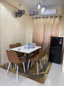 拿笃B&K Homestay Lahad Datu的一间配备有白色桌椅的用餐室