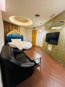 台北沃客商旅 承德馆的客房设有床、沙发和桌子。