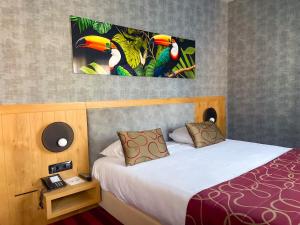 韦尔维耶威威斯湾德瓦克酒店的酒店客房设有一张床,墙上挂有绘画作品