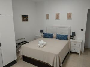 科尔多瓦Apartamentos Cordoba的一间卧室配有白色床和蓝色枕头