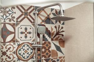 雅西Luxury Collection Studios at Q Residence Palas Mall的带淋浴的浴室(带瓷砖墙)