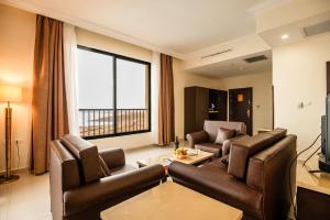索瓦马East hotel的客厅配有皮革家具和大窗户
