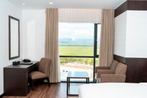 绥和市TUI BLUE Tuy Hoa的一间卧室配有一张床、一张书桌和一个窗户。