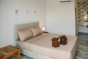 达叻府Chor Grande Resort的一间卧室,配有一张带两件大衣的床