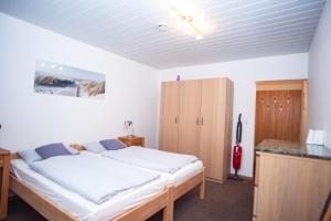 诺德奈Haus Ufen - In den Dünen 18c的一间卧室配有一张床和一个木制橱柜