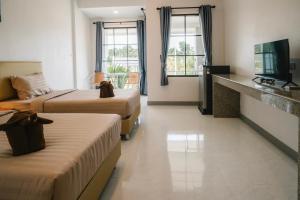 达叻府Chor Grande Resort的酒店客房设有两张床和电视。