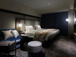 札幌Mitsui Garden Hotel Sapporo West的酒店客房带一张床、一张桌子和椅子