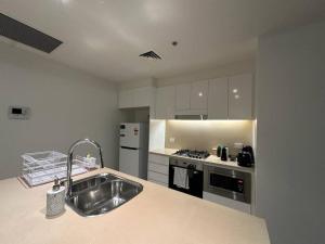 悉尼Cozy 2 Bedroom Apartment Darling Harbour的厨房配有水槽和炉灶