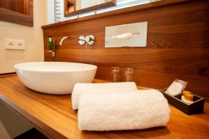 施韦比施哈尔利霸布鲁酒店的木制柜台上带白色碗水槽的浴室