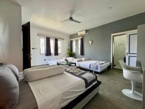 圣吉吉Villa Rumah Putih Abu Abu的一间卧室配有两张床和椅子