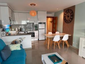 罗萨斯Almadrava Beach的厨房以及带蓝色沙发和桌子的客厅。