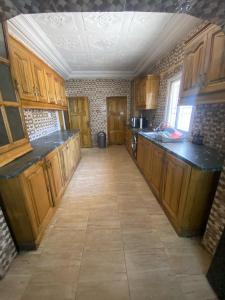 班珠尔The Girls Guest house的一间设有木制橱柜和瓷砖地板的大厨房
