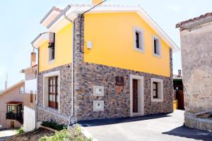 卢安科Casa Rural La Tayuela的黄色的石头外墙房子