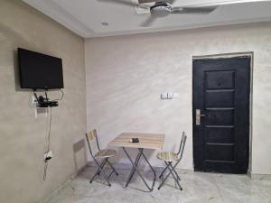 库马西Sigma Theta Homes - Kumasi Atimatim的配有桌椅和黑色门的房间