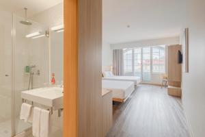 波尔图Moov Hotel Porto Centro的酒店客房带两张床和一间浴室