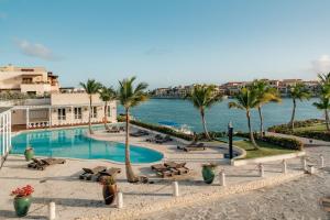 蓬塔卡纳Sports Illustrated Resorts Marina and Villas Cap Cana - All-Inclusive的棕榈树和水体的游泳池
