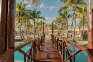 蓬塔卡纳Sports Illustrated Resorts Marina and Villas Cap Cana - All-Inclusive的棕榈树度假村的一座木桥