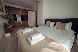 雅西Exclusive Collection Palas Mall Suites and Studios的一间卧室配有一张大床和毛巾