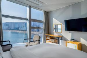 釜山Oceanstay Hotel的酒店客房设有一张床和一个大窗户