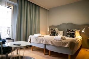 斯德哥尔摩斯堪迪克马耳曼酒店的一间卧室配有一张大床和一张桌子