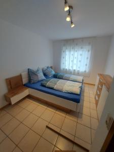 维赫尔Widmanns Ferienquartier的一间卧室配有一张带蓝色床单的床和一扇窗户。
