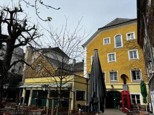 韦尔斯戈瑟布劳酒店的前面有雨伞的黄色建筑