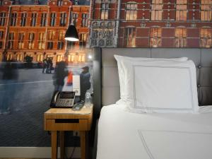 阿姆斯特丹瑞士酒店的一间卧室配有一张床和一张带电话的书桌